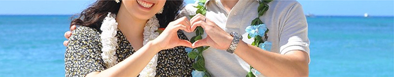 ハワイでハートを作ってる新婚さんの写真